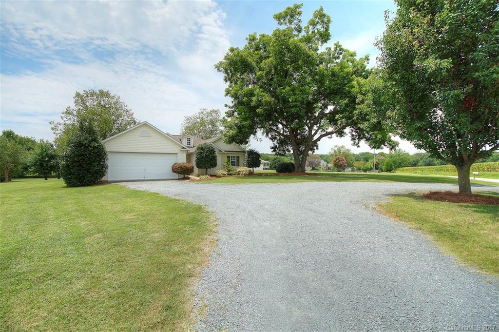6114 Olive Branch Road Wingate, NC 28174 - Photo 2 of 24 a view of a house with a big yard and large trees