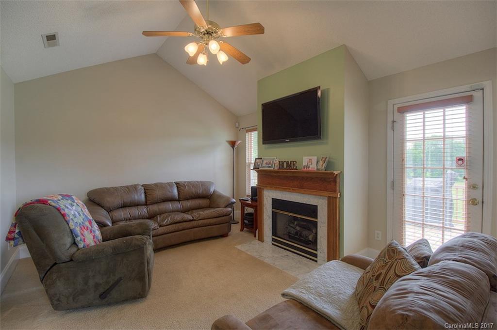 6114 Olive Branch Road Wingate, NC 28174 - Photo 13 of 24 a living room with furniture a flat screen tv and a fireplace