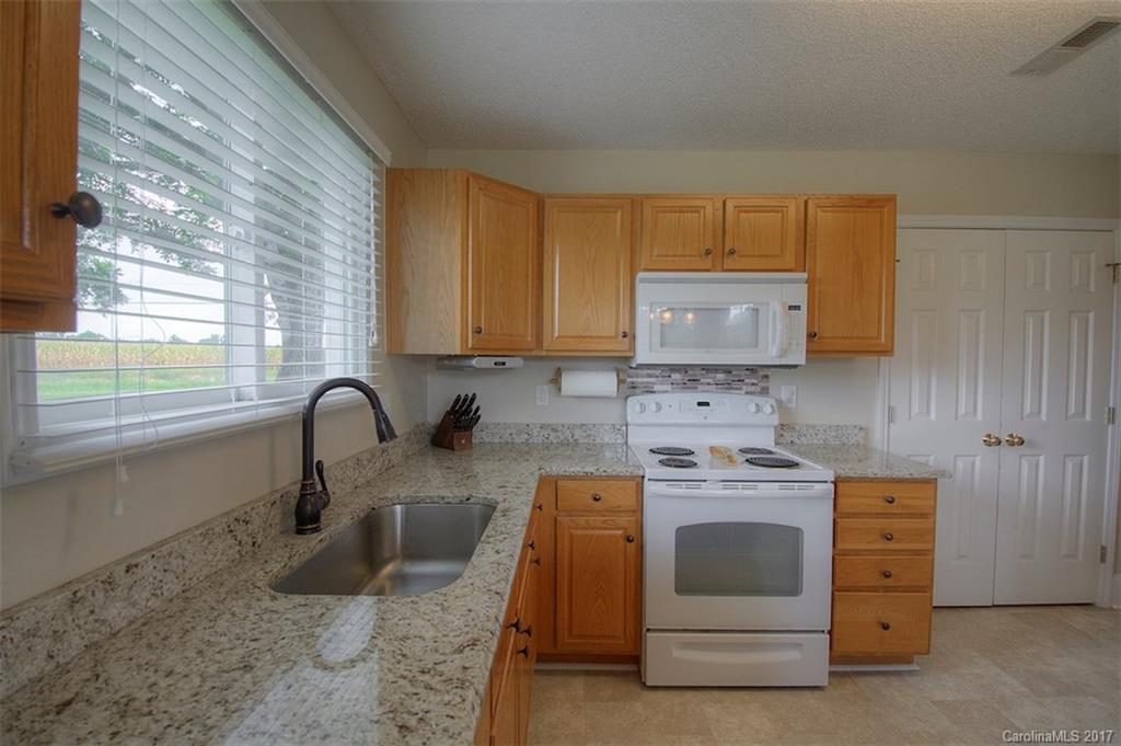 6114 Olive Branch Road Wingate, NC 28174 - Photo 17 of 24 a kitchen with a stove sink and cabinets