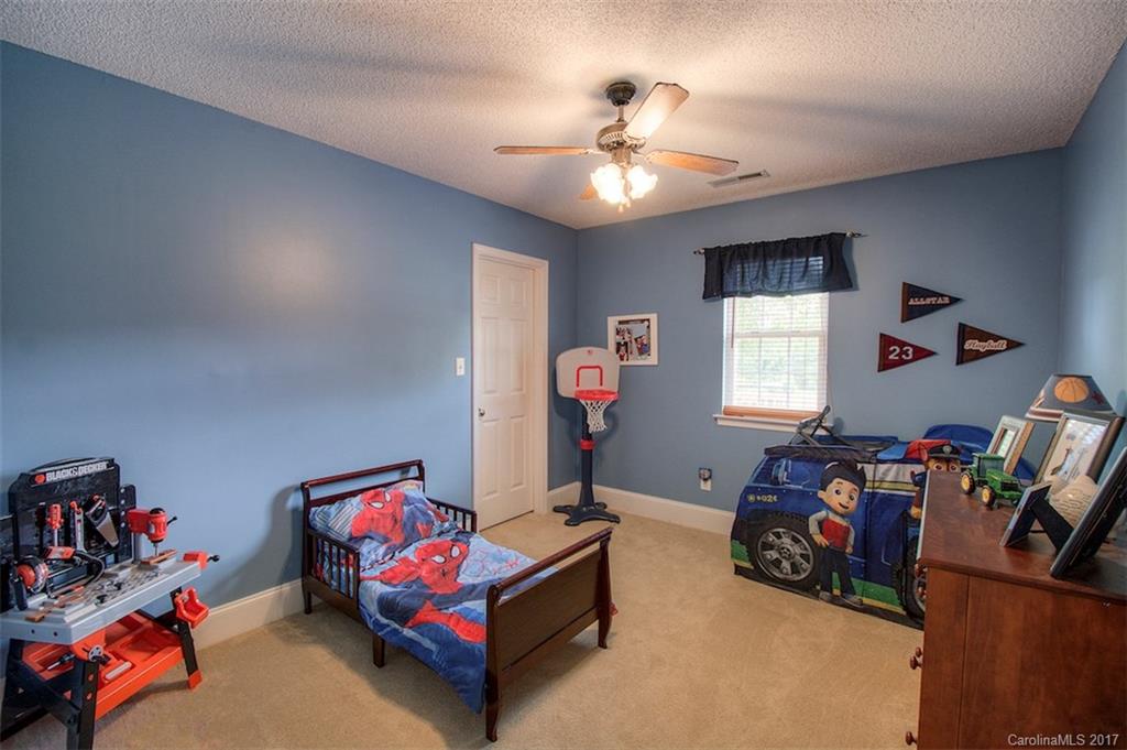 6114 Olive Branch Road Wingate, NC 28174 - Photo 22 of 24 a bedroom with bed and a chandelier