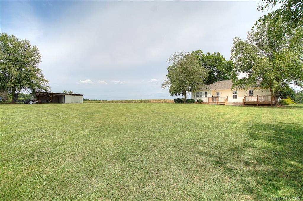 6114 Olive Branch Road Wingate, NC 28174 - Photo 6 of 24 a view of a green field with trees in the background