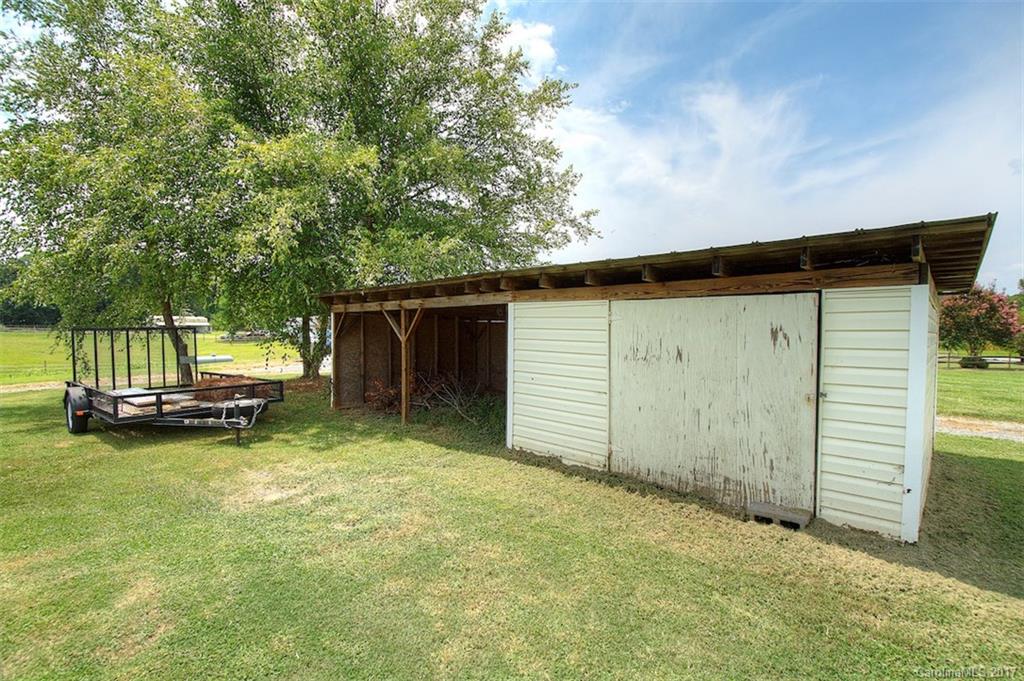 6114 Olive Branch Road Wingate, NC 28174 - Photo 9 of 24 a view of a backyard with small cabin and wooden fence