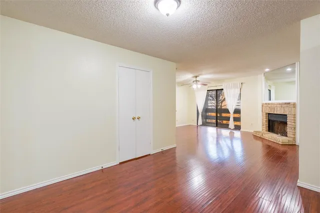 a view of a livingroom with wooden floor and a fireplace