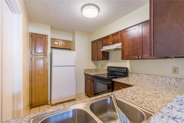 a kitchen with a sink stove and refrigerator