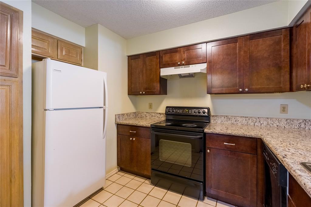 5840 Spring Valley Road, Unit 212 Dallas, TX 75254 - Photo 17 of 32 a kitchen with a stove and a refrigerator