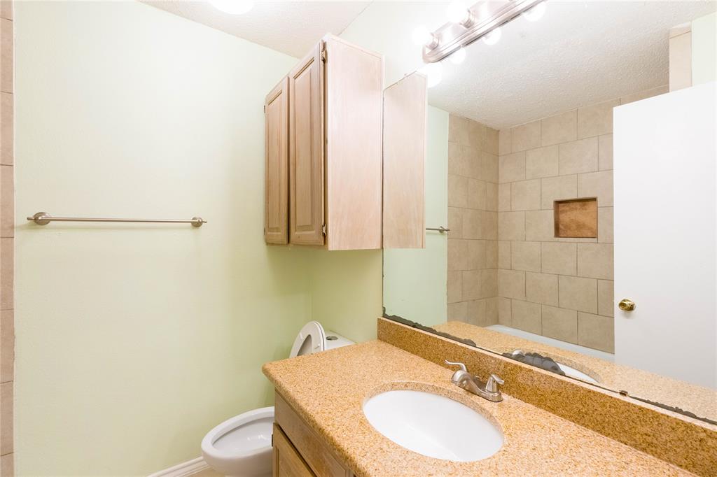 5840 Spring Valley Road, Unit 212 Dallas, TX 75254 - Photo 25 of 32 a bathroom with a granite countertop sink and a mirror