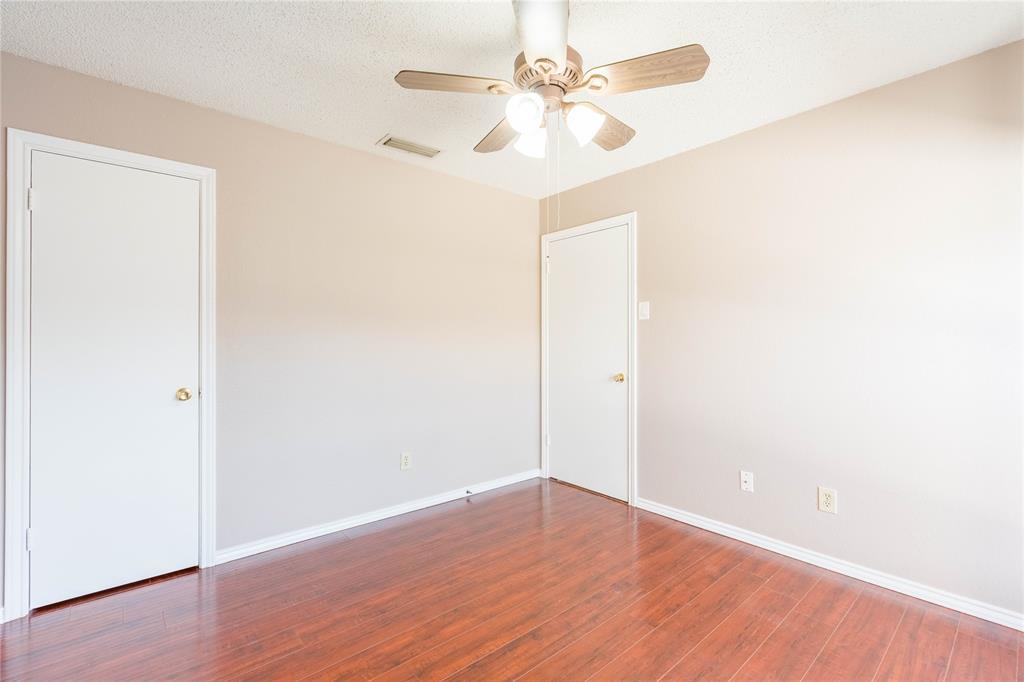 5840 Spring Valley Road, Unit 212 Dallas, TX 75254 - Photo 5 of 32 an empty room with wooden floor and fan