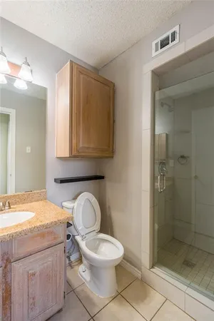 a bathroom with a granite countertop toilet a sink and a mirror