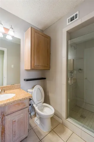 a bathroom with a granite countertop toilet a sink and a mirror