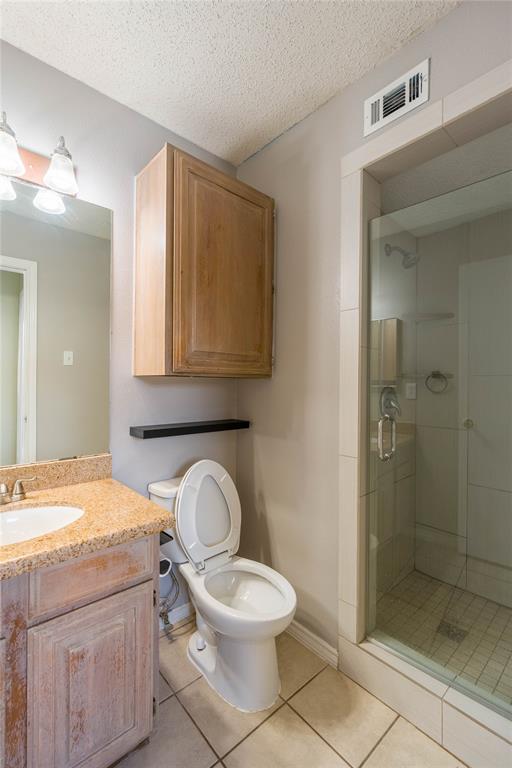 5840 Spring Valley Road, Unit 212 Dallas, TX 75254 - Photo 7 of 32 a bathroom with a granite countertop toilet a sink and a mirror