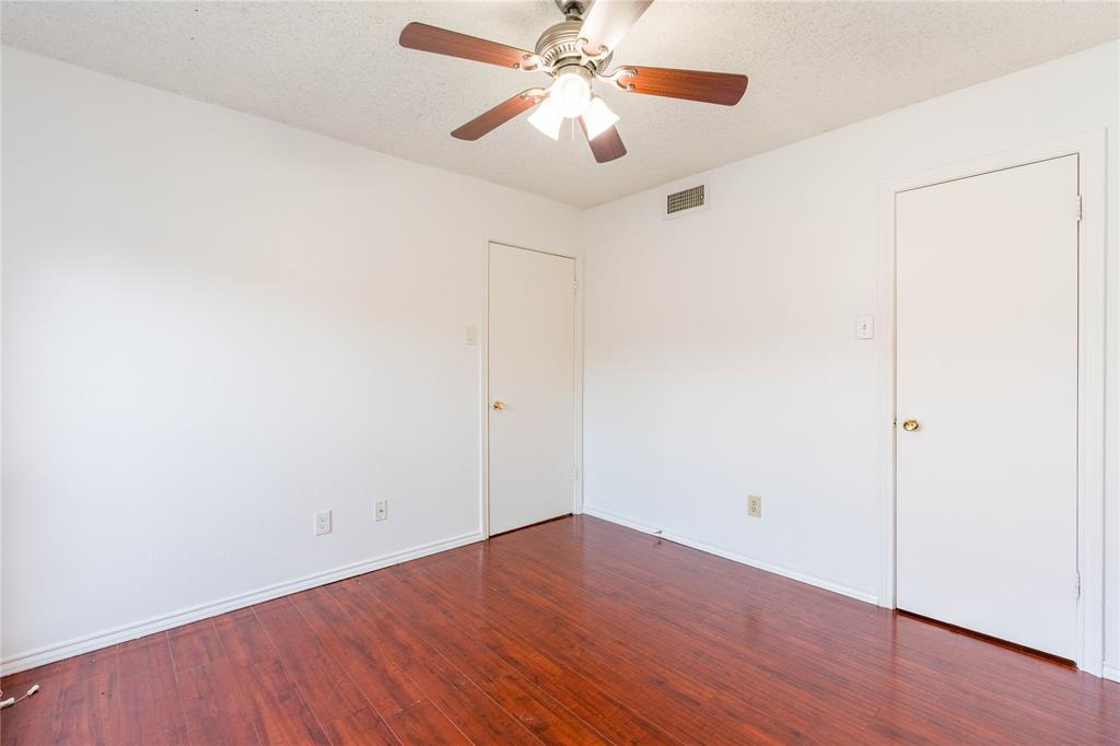 5840 Spring Valley Road, Unit 212 Dallas, TX 75254 - Photo 9 of 32 an empty room with wooden floor ceiling fan and a ceiling fan