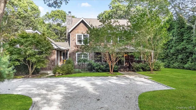 a front view of a house with a yard and tree s