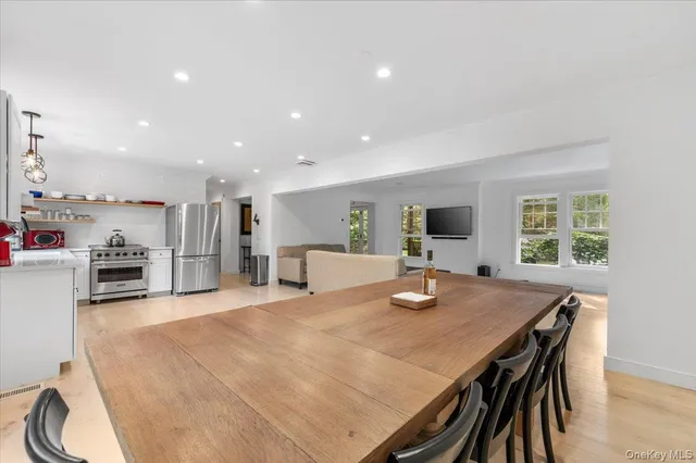 a dining room with stainless steel appliances a table and chairs