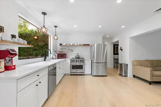 a kitchen with a sink stainless steel appliances and white cabinets