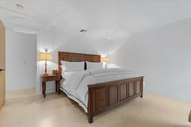 a bed sitting in a bedroom next to a lamp