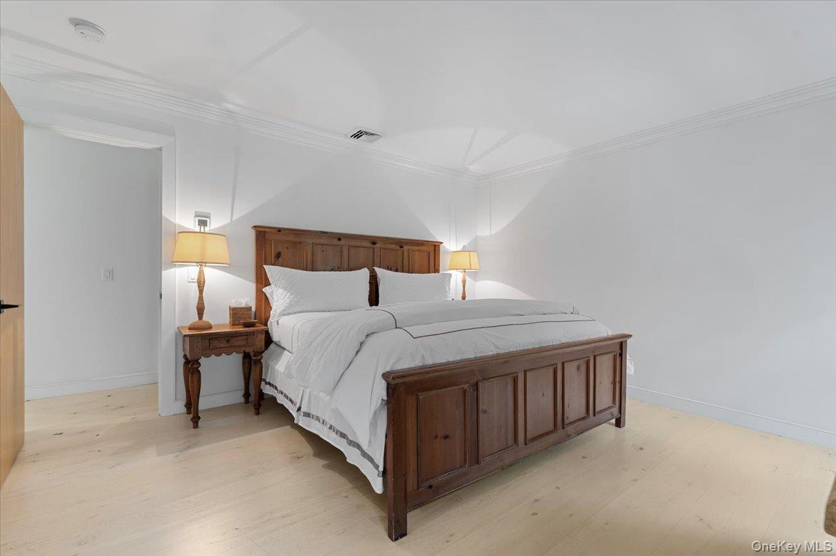 22 West Gate Road Wainscott, NY 11975 - Photo 18 of 42 a bed sitting in a bedroom next to a lamp