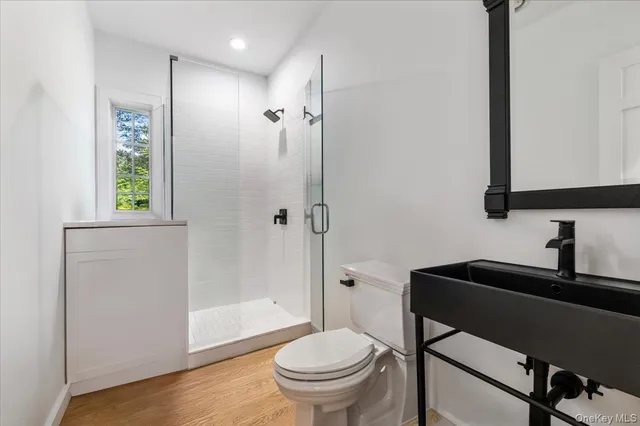 a bathroom with a toilet a sink and a mirror
