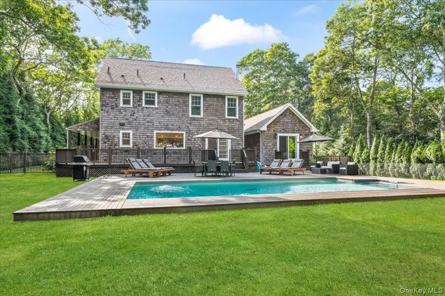 a front view of a house with garden and trees