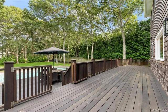 a view of backyard with wooden deck and seating space