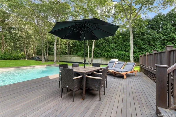 a view of swimming pool with lounge chair and wooden fence