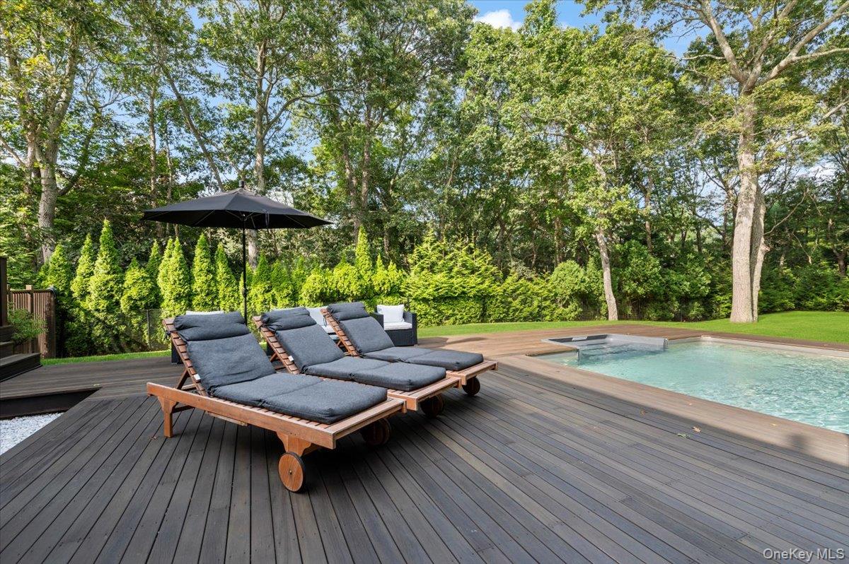 22 West Gate Road Wainscott, NY 11975 - Photo 37 of 42 a view of swimming pool with lounge chair and wooden fence