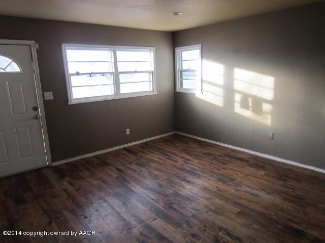 5107 Crockett Street Amarillo, TX 79110 - Photo 3 of 12 an empty room with wooden floor and windows