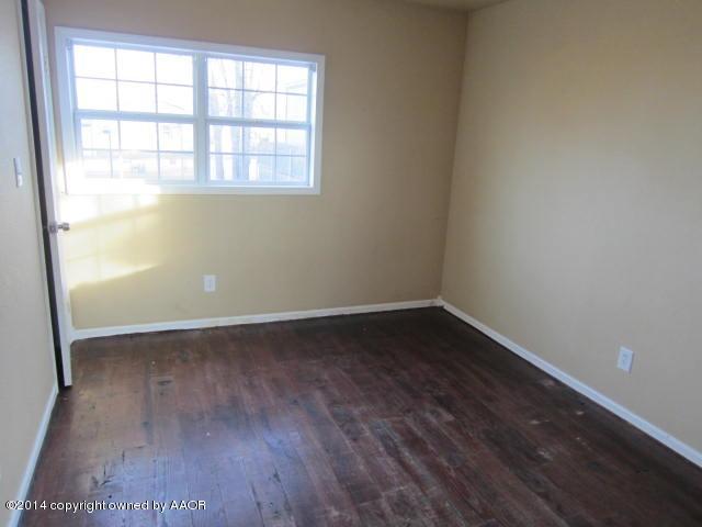 5107 Crockett Street Amarillo, TX 79110 - Photo 4 of 12 an empty room with wooden floor and windows