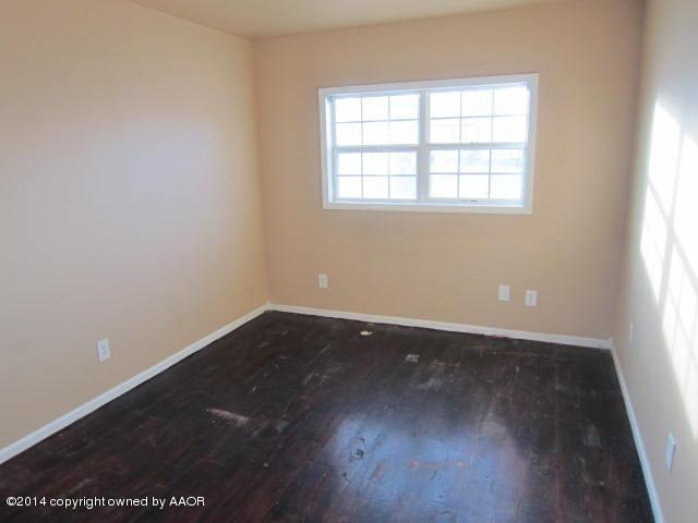 5107 Crockett Street Amarillo, TX 79110 - Photo 5 of 12 an empty room with wooden floor and windows