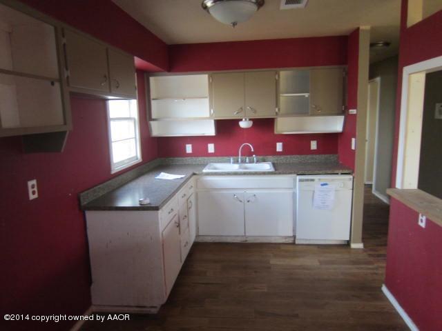 5107 Crockett Street Amarillo, TX 79110 - Photo 9 of 12 a kitchen with a sink a stove and cabinets