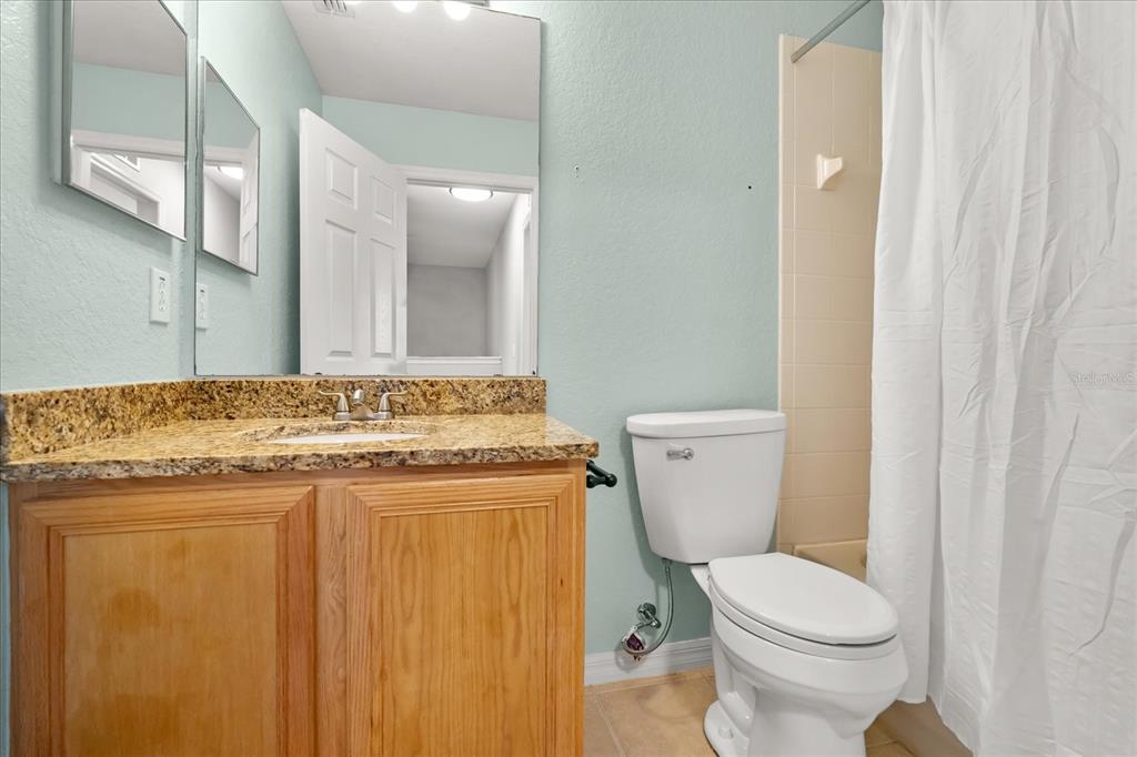 122 Capri Drive Davenport, FL 33897 - Photo 23 of 35 a bathroom with a granite countertop toilet sink and mirror
