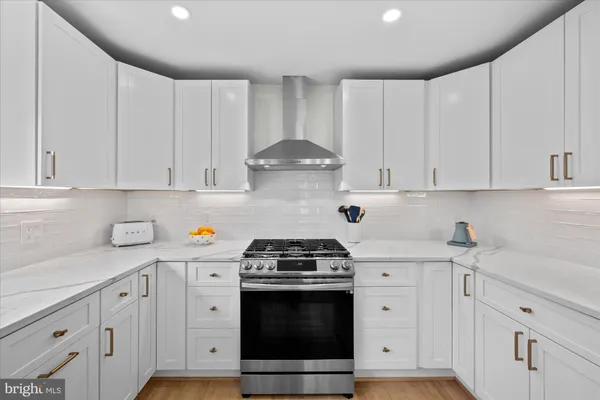a kitchen with white cabinets and white appliances
