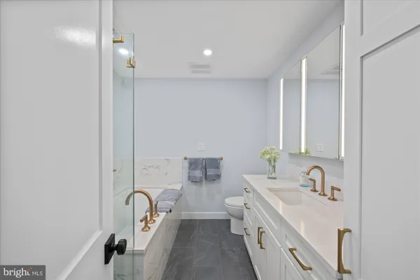 a bathroom with a double vanity sink a mirror and a bathtub