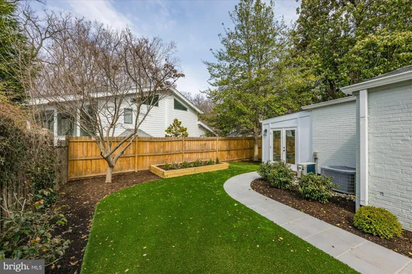 a view of backyard with potted plants and a bench