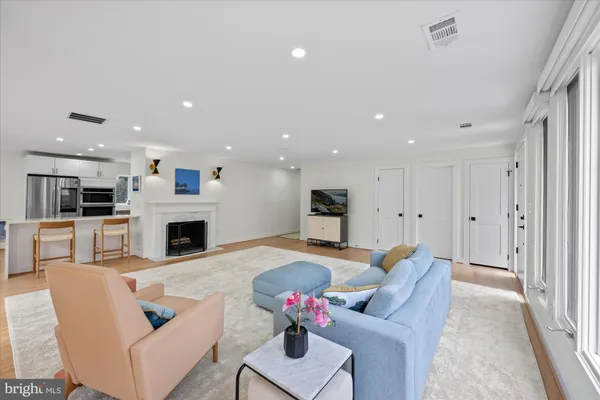 a living room with furniture a fireplace and a kitchen view