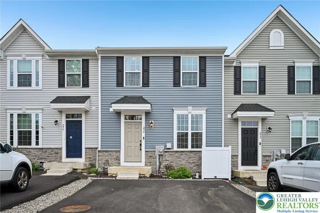 a front view of a house with a parking space