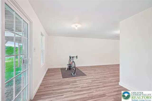 a view of a hallway with wooden floor and a floor to ceiling window