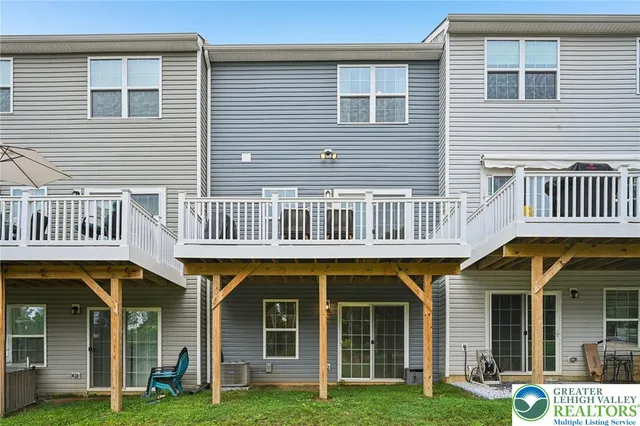 a view of a brick house with many windows and a yard
