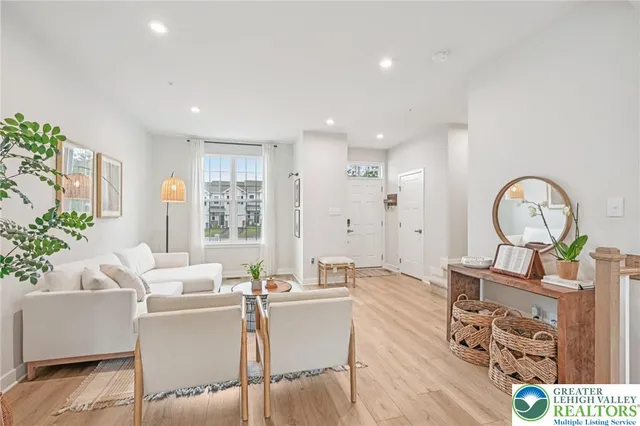 a living room with furniture a window and a wooden floor