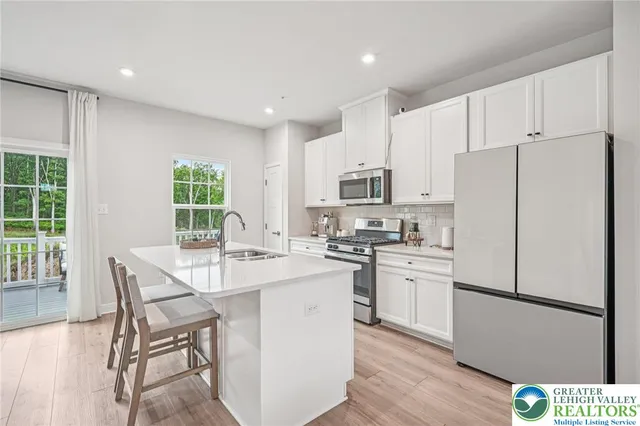 a kitchen with white cabinets and white appliances
