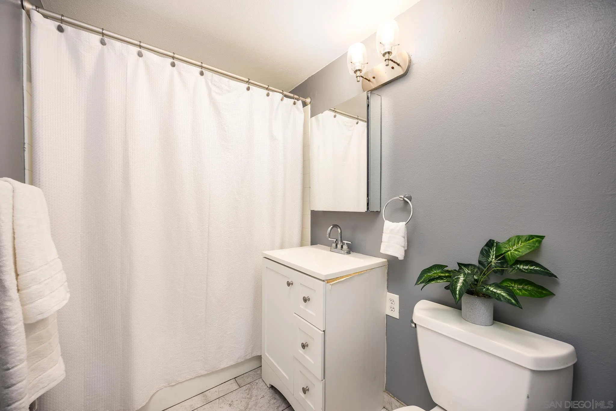 3568 Front Street, Unit D San Diego, CA 92103 - Photo 13 of 24 a bathroom with a toilet a sink and a mirror
