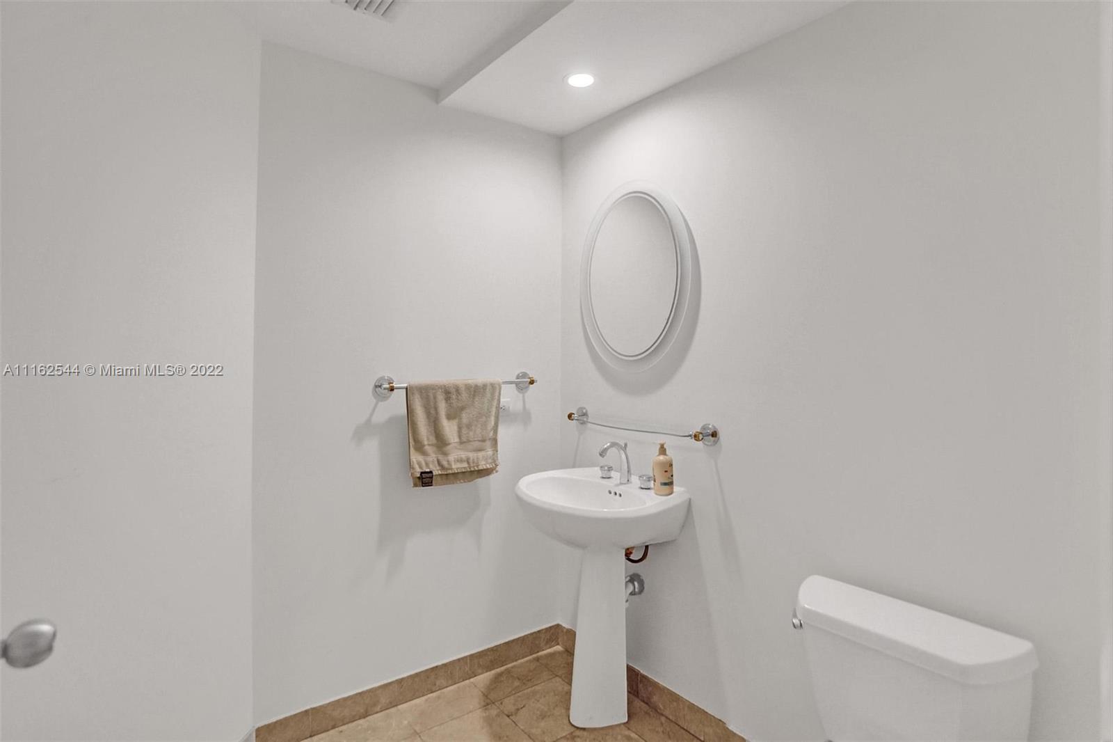 801 Brickell Key Boulevard, Unit 1507 Miami, FL 33131 - Photo 17 of 26 a bathroom with a sink a toilet and a mirror