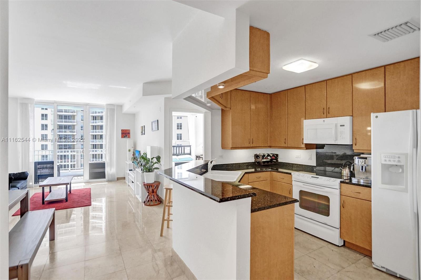 801 Brickell Key Boulevard, Unit 1507 Miami, FL 33131 - Photo 6 of 26 a kitchen with stainless steel appliances granite countertop a stove a sink dishwasher a refrigerator a oven and white cabinets with wooden floor
