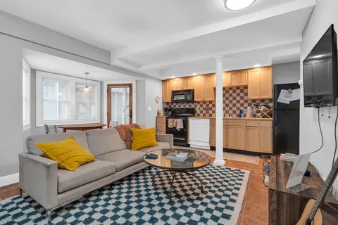 a living room with furniture a rug and a flat screen tv