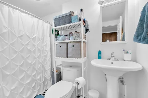 a bathroom with a sink toilet and mirror