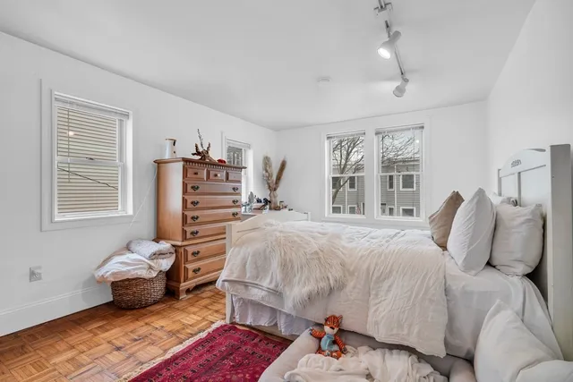 a bedroom with a bed and wooden floor