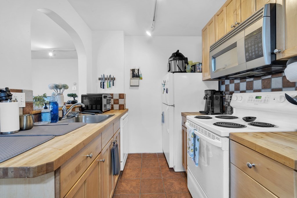 493-495 East 7th Street Boston, MA 02127 - Photo 8 of 22 a kitchen with stainless steel appliances granite countertop a stove and a sink