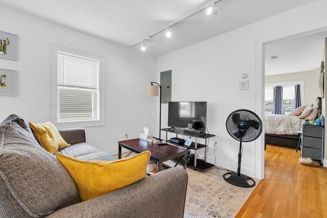 a living room with furniture a flat screen tv and a window