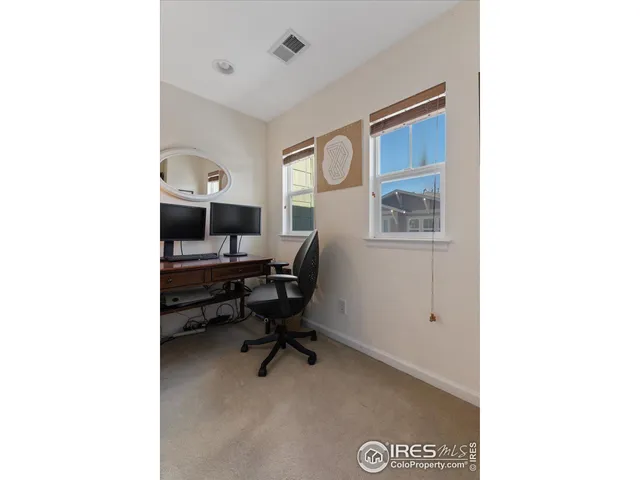 a view of a workspace with furniture and a window