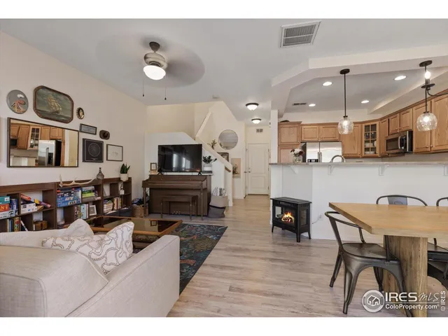 a living room with stainless steel appliances kitchen island granite countertop furniture and a fireplace