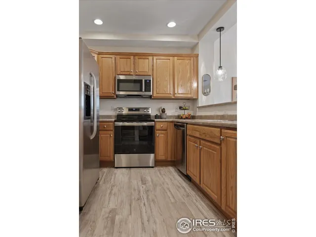 a kitchen with stainless steel appliances granite countertop a stove top oven a sink and a microwave